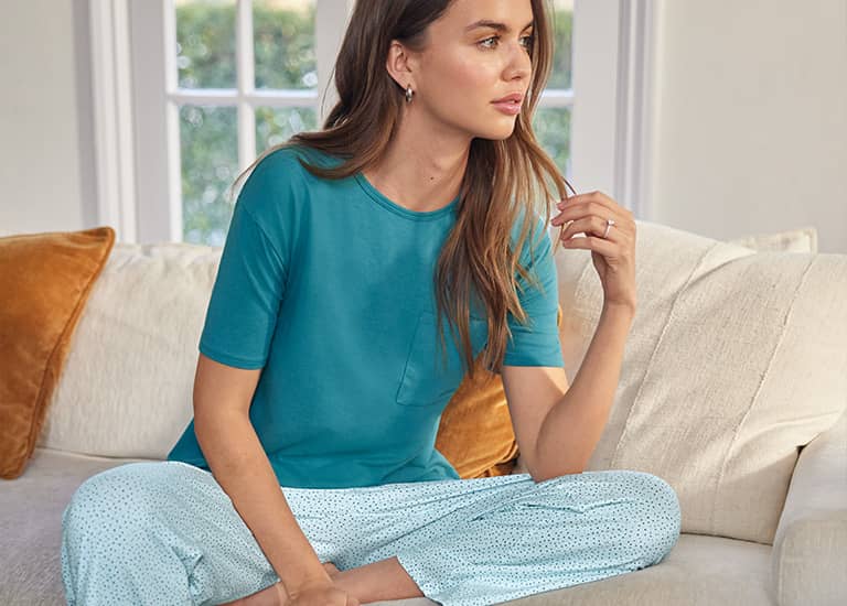 woman in bed wearing new styles from Jockey sleepwear