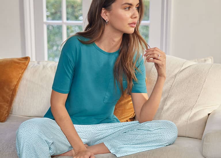 woman in bed wearing new styles from Jockey sleepwear