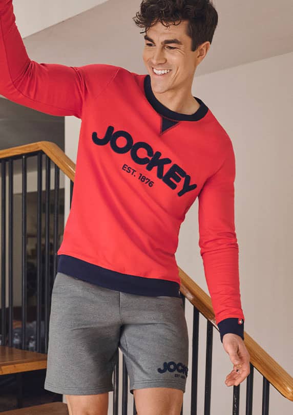 man walking downstairs in red Jockey sweatshirt