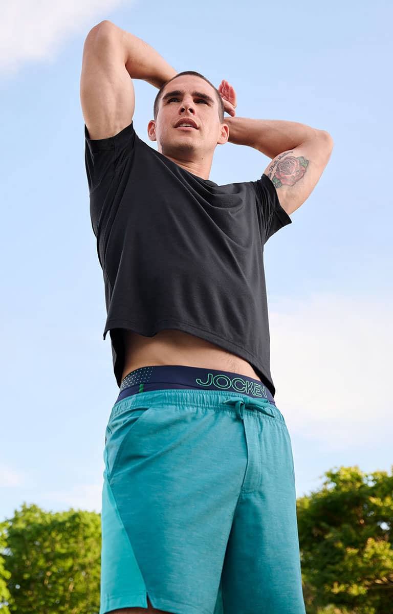 man stretching wearing everactive collection pieces outside