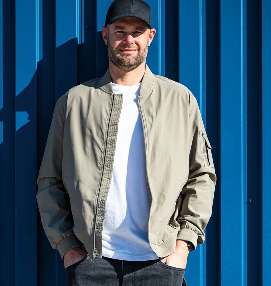 Shane Van Gisbergen leaning aginst a wall